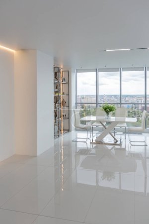 Photo for A white and very bright luxury fashionable apartment on a high floor with a free layout, a living room with expensive furniture and panoramic glazing - Royalty Free Image