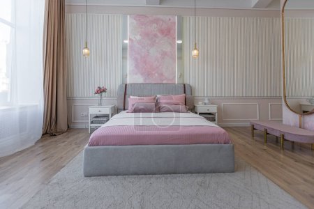 ein naher Blick auf das Schlafzimmer in einem modernen gemütlich weichen Interieur in warmen zarten Pastellrosa und Beige-Farben