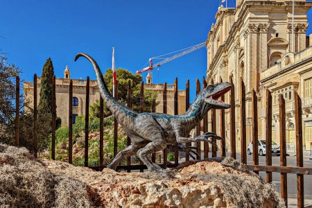 Foto de Estatua de Blue Velociraptor que protagonizó una película reciente, Jurassic World Dominion, que fue filmada parcialmente en Malta, ahora colocada en Birgu para turistas: Birgu, Malta - 11 de septiembre de 2022 - Imagen libre de derechos