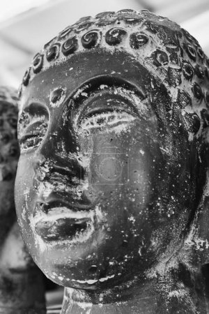 Closeup cement Buddha head. Modern Art concept. Black and white photography, soft focus