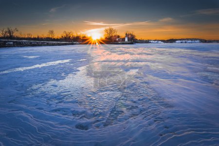 Téléchargez les photos : Vue hivernale du Québec avec coucher de soleil sur le fleuve Saint-Laurent gelé.2024 - en image libre de droit