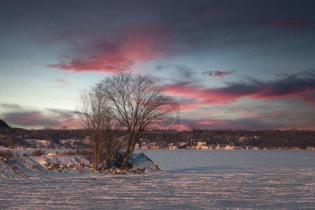 Winter view of the Quebec with a sunset on the frozen St. Lawrence river. 2024