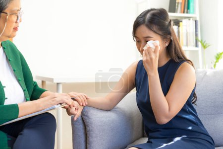 Foto de Médico psicólogo asiático consulta sesión de psicoterapia con mujer joven deprimida. Concepto de psicología y terapia mental. - Imagen libre de derechos