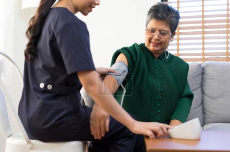 Foto de Médico o enfermero usando medidor de presión arterial con pacientes de edad avanzada en Hospitales. - Imagen libre de derechos