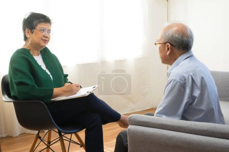 Téléchargez les photos : Déprimé asiatique senior homme partage des problèmes lors de la séance de thérapie avec une femme psychiatre - en image libre de droit