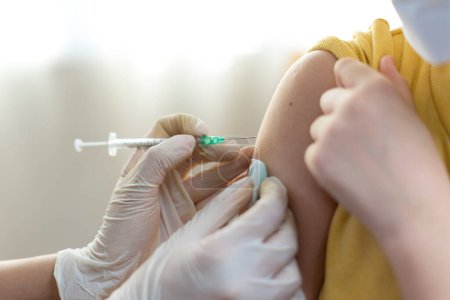 Foto de Enfermera haciendo inyección en hombro de adolescente durante la vacunación, concepto coronavirus - Imagen libre de derechos