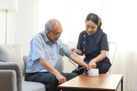 Photo for Doctor or nurse using blood pressure gauge with old male patient at Hospital - Royalty Free Image
