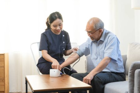 Photo for Doctor or nurse using blood pressure gauge with old male patient at Hospital - Royalty Free Image
