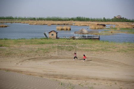 Téléchargez les photos : Le lac Shahu se trouve à côté de la montagne Helan et du fleuve Jaune, à 42 kilomètres de Yinchuan, région autonome de Ningxia Hui. Il a cinq sources paysagères de désert, d'eau, de roseau, d'oiseaux et de montagnes combinées organiquement. Il s'agit d'un transit important - en image libre de droit