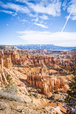 Téléchargez les photos : Bryce Canyon accented in freshly fallen snow and distant mountains and brilliantly colored orange cliffs. - en image libre de droit