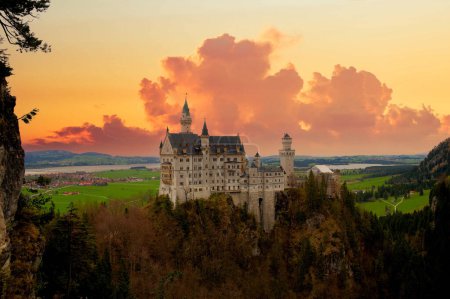 Téléchargez les photos : Château de Newschwander dans les Alpes bavaroises d'allemand dans la soirée avec un ciel dramatique. - en image libre de droit