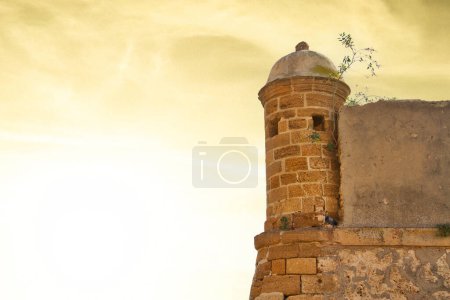 Photo for Well aged garitas protecting the Spanish city of Cadiz against a brightly lit sky during sunset. - Royalty Free Image