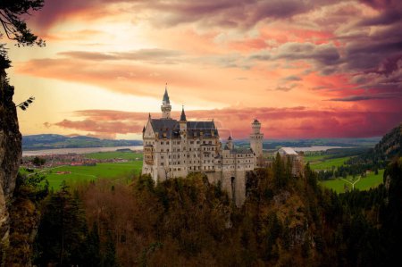 Téléchargez les photos : Château de Newschwander dans les Alpes bavaroises d'allemand dans la soirée avec un ciel dramatique. - en image libre de droit