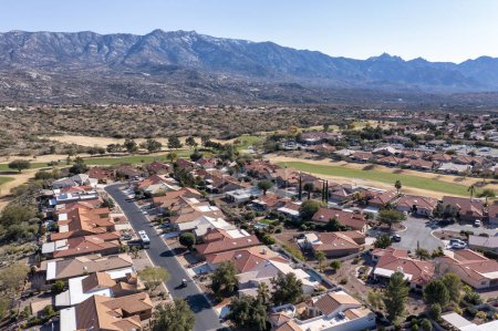 Téléchargez les photos : Aerial view of a suburban residential community with a golf course and tennis courts in a desert environment with the Catalina Mountains in the background near Tucson, Arizona. - en image libre de droit