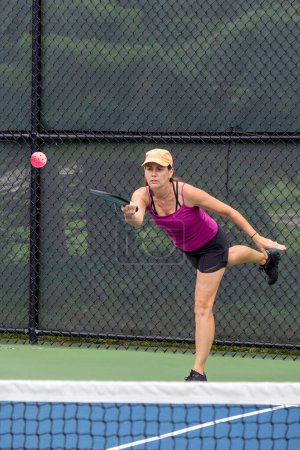 Téléchargez les photos : A pickleball player serves the ball on a suburban pickleball court during summer. - en image libre de droit