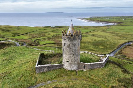 Photo for Aerial view of Doonagore Castle, a round 16th-century tower house with a small walled enclosure located south of the coastal village of Doolin in County Clare, Ireland. - Royalty Free Image