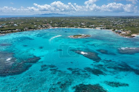 Aerial view of Island Harbour with a speedboat near Scilly Cay in the foreground and Saint Martin in the distance on the island of Anguilla.