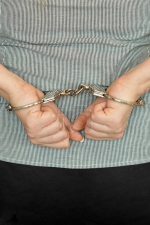 Photo for Woman handcuffed hands at the back. Prisoner or arrested close-up of hands in handcuff - Royalty Free Image