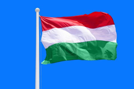 Ungarn-Flagge weht vor blauem Himmel, hautnah. Ungarn-Flagge am blauen Himmel. Flagge Ungarn auf blauem Himmel Hintergrund
