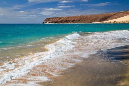 Téléchargez les photos : Le magnifique littoral avec une eau bleue turquoise, des plages lumineuses et des embruns sur la plage de Risco del Paso, à l'est de Fuerteventura, Îles Canaries, Espagne - en image libre de droit