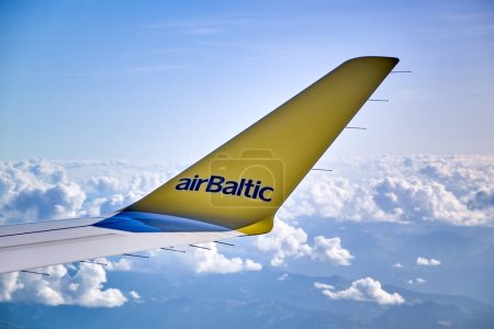 Foto de Alitas de ala de avión amarillo Letrero del logotipo de Airbaltic sobre cielo nublado azul - Imagen libre de derechos