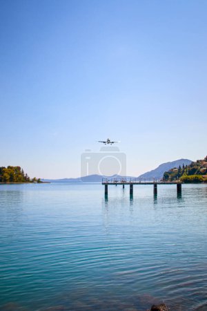 Foto de Baja aproximación de aterrizaje de un avión sobre una bahía marítima al aeropuerto de Corfú a través de una plataforma, Kerkyra, Grecia - Imagen libre de derechos