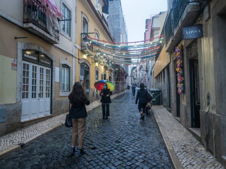 Photo for Lisbon, Portugal, October 30, 2021: View of street in Baixa at Lisbon center, Autumn rainy evening. - Royalty Free Image