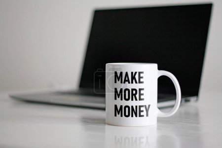 Téléchargez les photos : Gagner plus d'argent est montré en utilisant un texte sur la tasse blanche - en image libre de droit