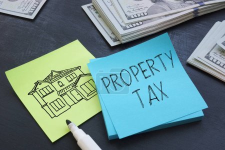 Foto de Impuesto a la propiedad se muestra utilizando un texto y una foto de dólares y la imagen de la casa - Imagen libre de derechos