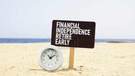 Photo for Financial independence retire early FIRE is shown using a text and photo of the clock on the beach - Royalty Free Image