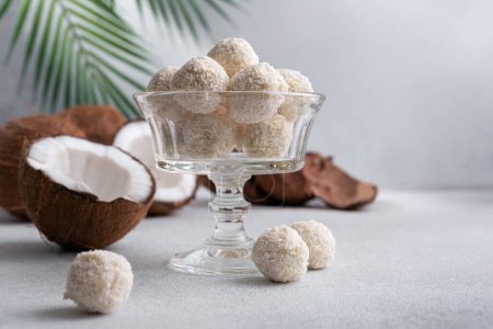 Photo for Coconut balls, raw and healthy sugar free candies. Vegetarian energy sweets. Round tasty dessert in glass bowl. Healthy organic food for kids. - Royalty Free Image