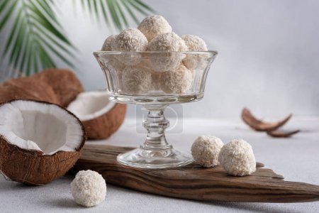 Coconut balls, raw and healthy sugar free candies. Vegetarian energy sweets. Round tasty dessert in glass bowl. Healthy organic food for kids.