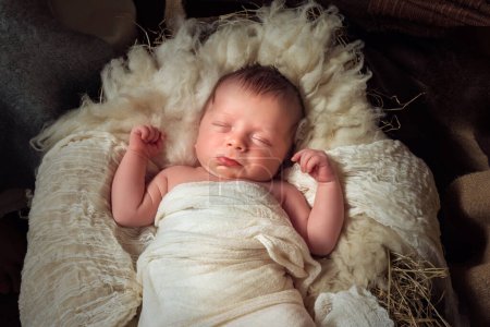 Live Christmas nativity scene of 8 days old baby boy sleeping in a manger