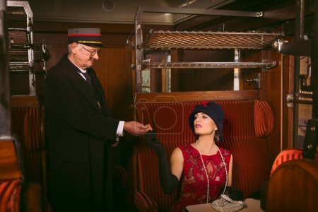 Reenactment scene of a vintage steam train conductor in a 1927 authentic first class train interior
