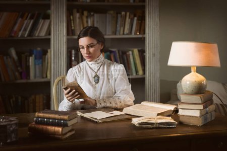Schöne Dame in edwardischem Rock und Spitzenbluse mit hohem Kragen sitzt in der Bibliothek. Sie könnte Lehrerin oder sogar Schulleiterin werden.