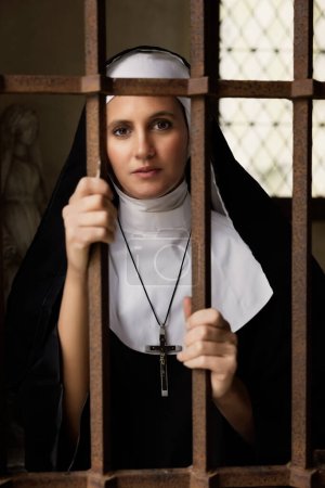 Photo for Young adult woman dressed in authentic habit and veil of a catholic nun in a medieval chapel - Royalty Free Image