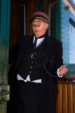Téléchargez les photos : Scène de reconstitution d'un ancien chef de train au départ du wagon de première classe - en image libre de droit