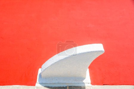 vague de béton blanc se démarque sur un fond rouge vif