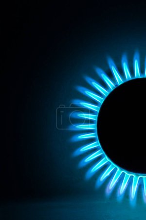 Photo for A hundred dollar bill on a gas burner with a burning fire on a black background, the front and back background is blurred with a bokeh effect - Royalty Free Image