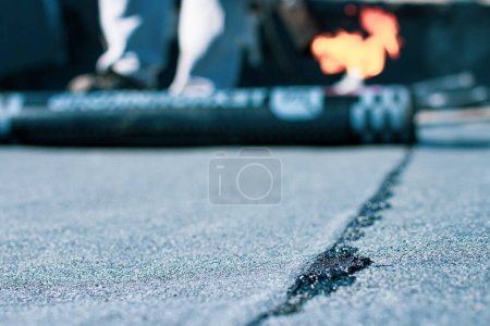 Photo for Roll roofing Installation with propane blowtorch during construction works - Royalty Free Image