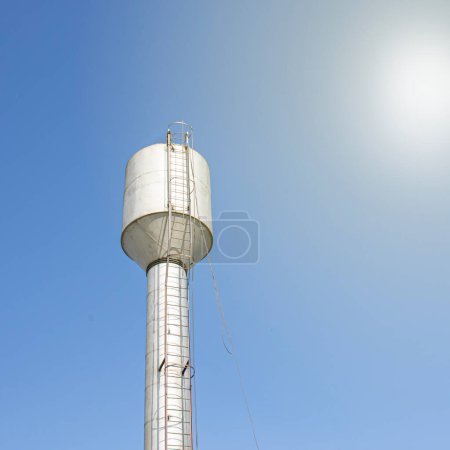 Téléchargez les photos : Un château d'eau fournissant au village de l'eau potable propre contre un ciel bleu - en image libre de droit