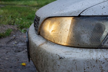 Foto de Muy sucio faro del coche primer plano, durante el mal tiempo en una carretera sucia, problema con la iluminación y la visibilidad en la carretera - Imagen libre de derechos