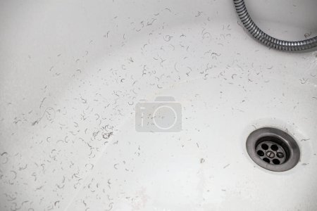 rasierte Haare aus dem Intimbereich des Schambereichs nach der Rasur und Enthaarung verbleibenden an den Wänden des Badezimmers Waschbecken, Nahaufnahme Textur