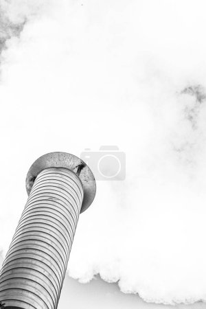 Foto de Chimenea metálica de una central geotérmica con estructura de tubería de acero inoxidable con humo y vapor - Imagen libre de derechos