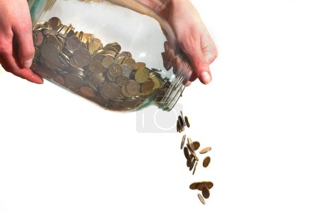 money poured from a glass jar on a white background
