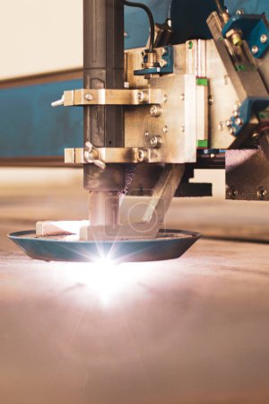 Découpe laser en gros plan de métal sur une machine CNC, dans une grande usine de machines-outils au centre du pays