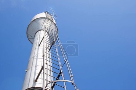 a water tower providing the village with clean drinking water against a blue sky