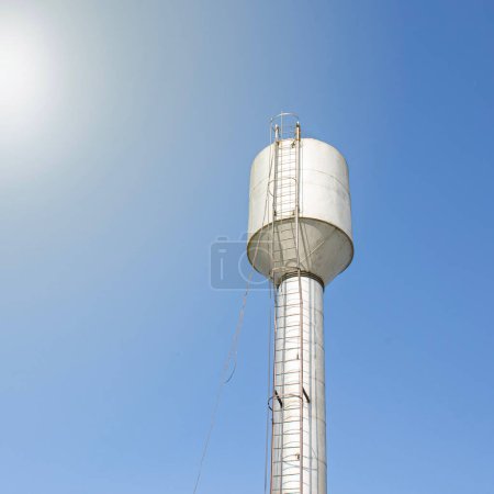 Téléchargez les photos : Un château d'eau fournissant au village de l'eau potable propre contre un ciel bleu - en image libre de droit