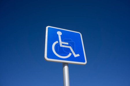 Téléchargez les photos : Panneau de stationnement bleu pour handicapés avec fond bleu ciel et salle pour l'espace de copie - en image libre de droit