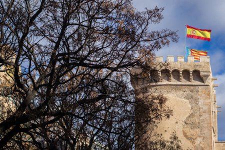 Téléchargez les photos : VALENCIA, ESPAGNE - 8 mars 2024 : Vue latérale des tours Quart (Tours de Quart) du XVe siècle à Valence avec les drapeaux d'Espagne et de Valence au sommet. Les Tours ont été construites entre 1441 et 1493. - en image libre de droit